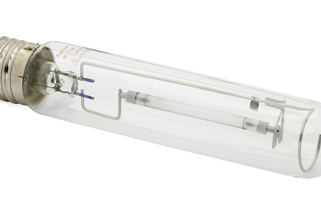 A clear high-pressure sodium light bulb with metal components inside, lying on a white background.