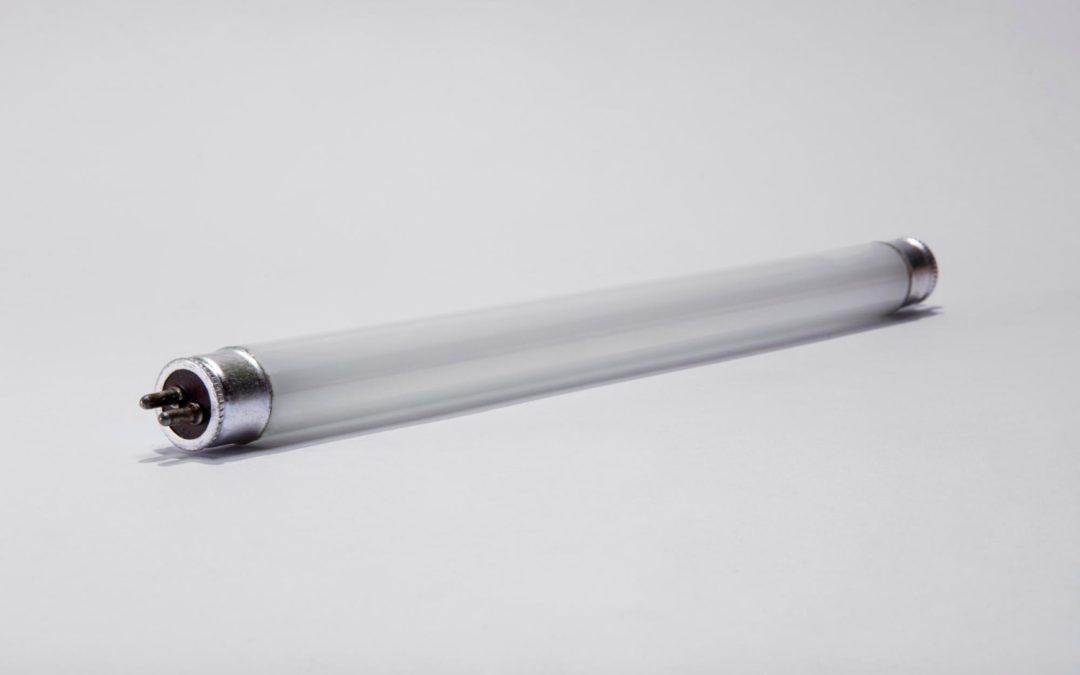 A fluorescent tube light lying on a plain white surface.