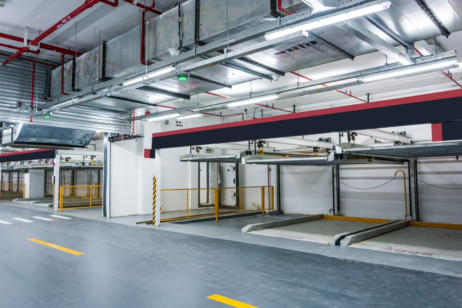 Empty, modern underground parking garage with yellow lines and metal structures for car stacking.